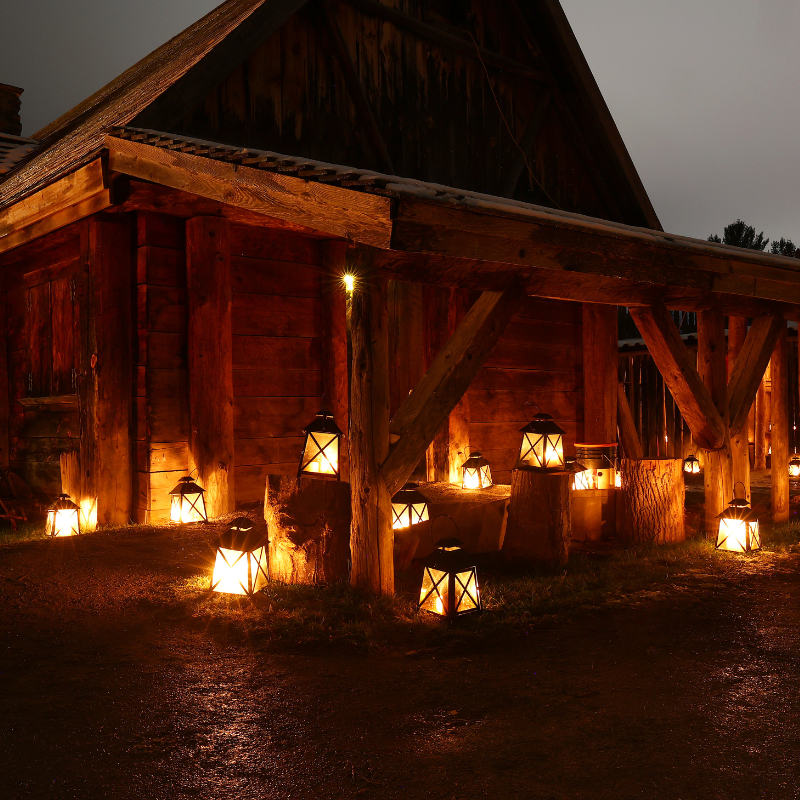 Saint Marie among the hurons. Outside a barn with lots of candle lamps/ lights spread out the field 